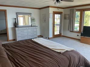 Une chambre à coucher avec un lit, une commode et une fenêtre avec des rideaux.