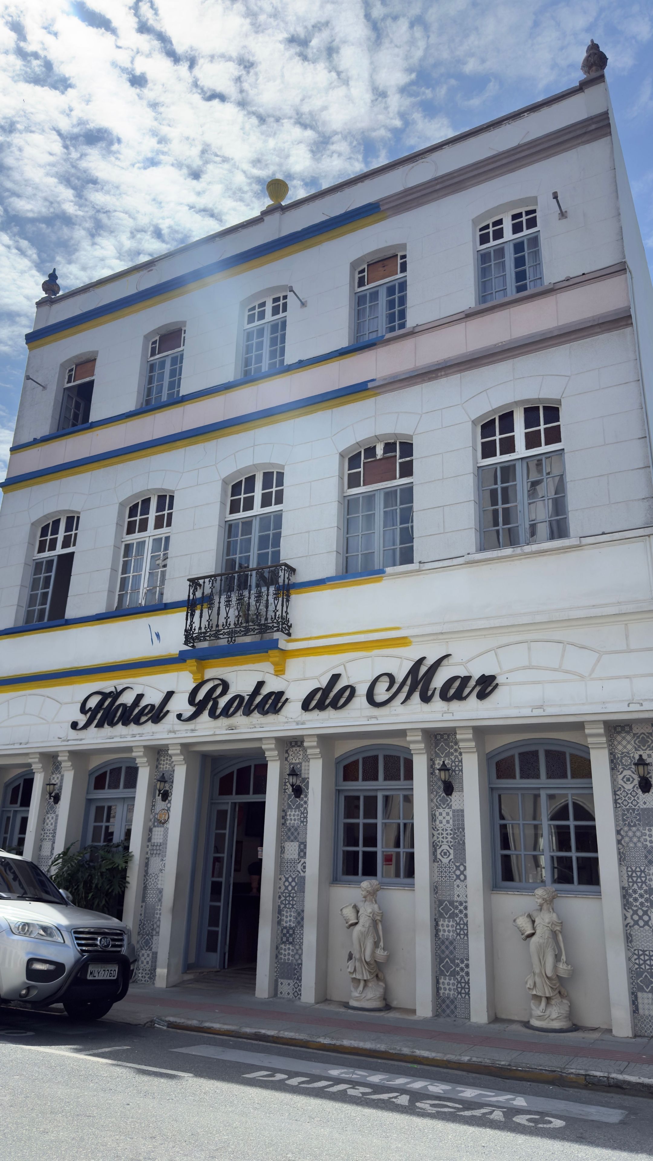A hotel with a white facade, blue trim, and a sign reading 'Hotel Rota de Mar'.