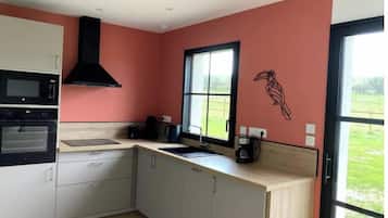 Una cucina con forno a microonde, forno e una finestra vista verde.