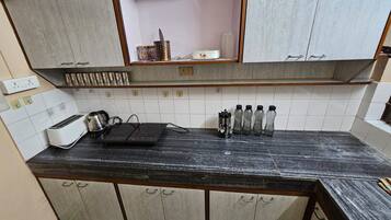 A kitchen with a black countertop, white tiled backsplash, and wooden cabinets.