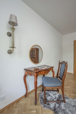 A room with a wooden table, a chair, a mirror, and a wall-mounted lamp. - Lumina 3-room Apt w/ Balcony I Center (Warszawa)