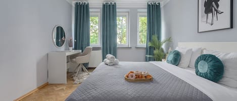 Une chambre à coucher comprenant un lit, un bureau, une chaise, une fenêtre avec des rideaux et un tableau encadré accroché au mur.