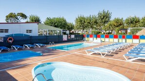 Et poolområde med flere pools og liggestole.