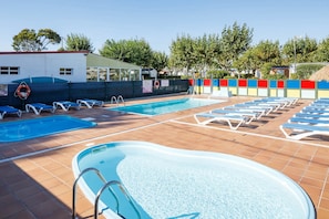 Zona de piscina con múltiples piscinas y tumbonas.