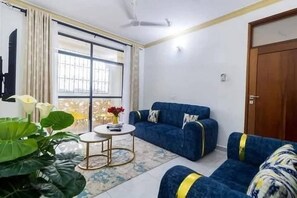 Ein Wohnzimmer mit einer Couch, einem kleinen runden Tisch und einem großen Fenster.