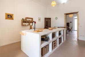 A modern kitchen with a central island, wooden cabinets, and a hanging light fixture. - Approdo Mediterraneo by Wonderful Italy (Syracuse)
