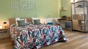 Een hotelkamer met een bed, een bureau, een stoel, een kledingkast en kunst aan de muur.