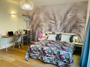 Un dormitorio con una cama, un escritorio y una silla.