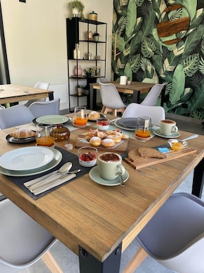 A breakfast setting with a variety of food items, including pastries, fruits, and beverages, arranged on a wooden table. - Bed& Breakfast Florida 7 - camera 1 (Pertegada)