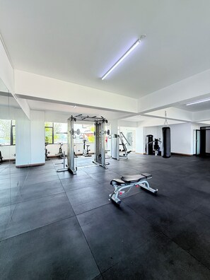 A spacious gym with various exercise equipment, large windows, and a clean, modern design. - Stylish Kilimani 2BR with Pool, Wi-Fi and Free Parking near Yaya Centre (Nairobi)