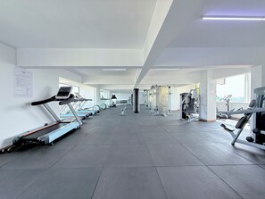 Un gimnasio con cintas de correr, máquinas de pesas y un saco de boxeo.