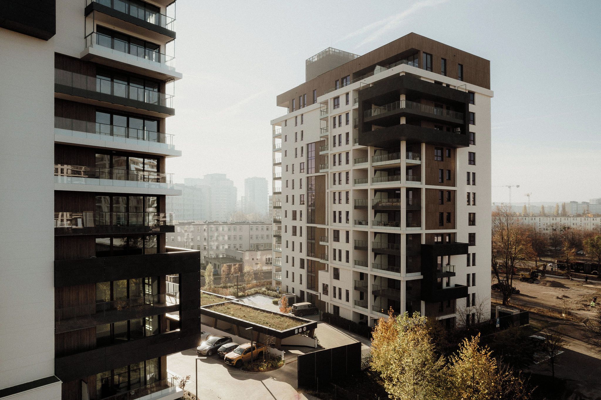 A high-rise building with multiple balconies and a rooftop garden.