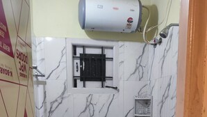 Un baño con inodoro, ducha y calentador de agua.
