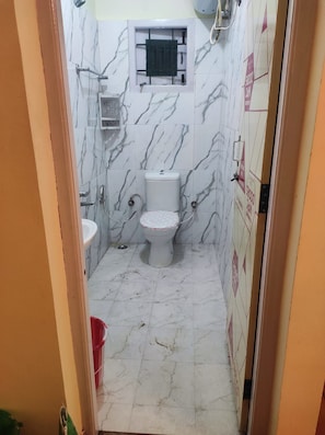 A small bathroom with a toilet, a sink, and a shower area. - VISA HOMESTAY
Private Cottage @ Your Budget
family-friendly and pet-friendly (Kodaikanal)
