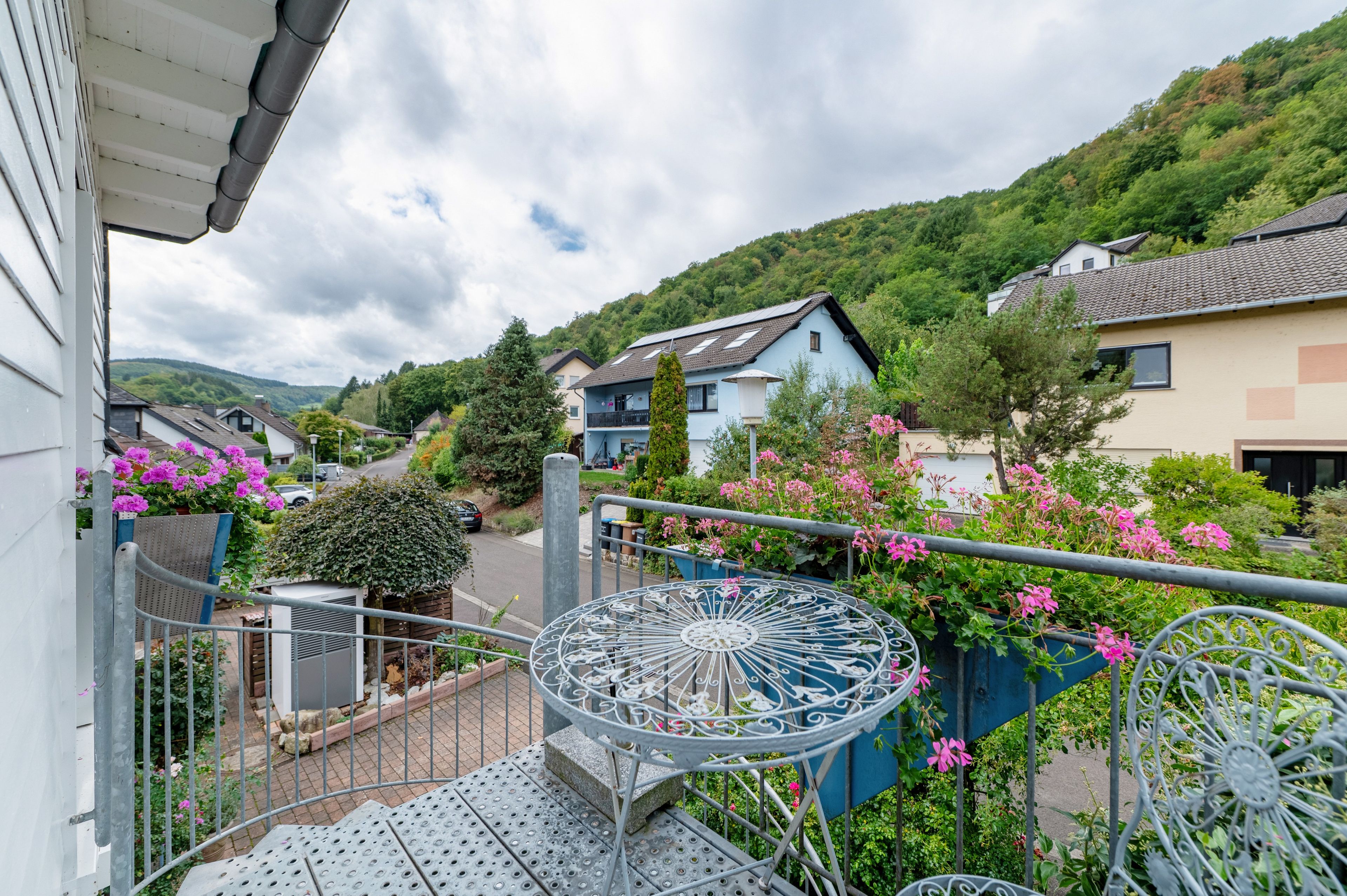 A residential area with houses, a street, and a decorative metal fence.
