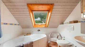 A bathroom with a freestanding bathtub, a toilet, and a sink.