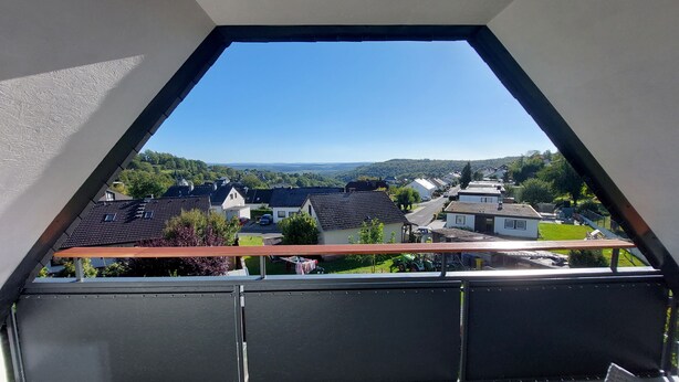 A view from a window with a triangular frame, overlooking a residential area with houses and a clear sky. - Beautiful 1-bedroom apartment in charming Winden perfect for relaxing (Winden)