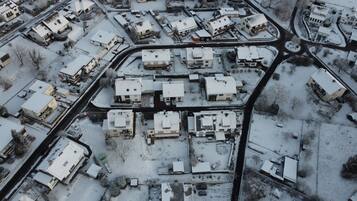 Ett flygbildsbild av ett bostadsområde med flera hus, vägar och en liten vattenväg.