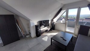 A modern living room with a flat-screen TV, a coffee table, and a sofa. - Beautiful 1-bedroom apartment in charming Winden perfect for relaxing (Winden)