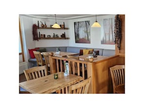 A cozy restaurant with wooden tables and chairs, pendant lighting, and artwork on the walls. - 2.4/t1 Holiday Home Park \"freesenbruch\" (Zingst)