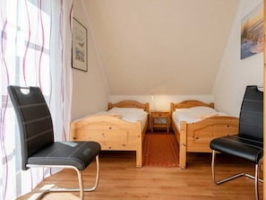 A small, cozy room with two wooden beds, a bench, and a chair. - 2.4/t1 Holiday Home Park \"freesenbruch\" (Zingst)