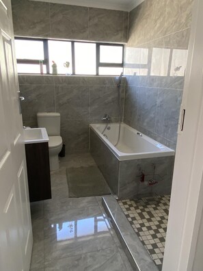Ein Badezimmer mit Toilette, Badewanne und Dusche.