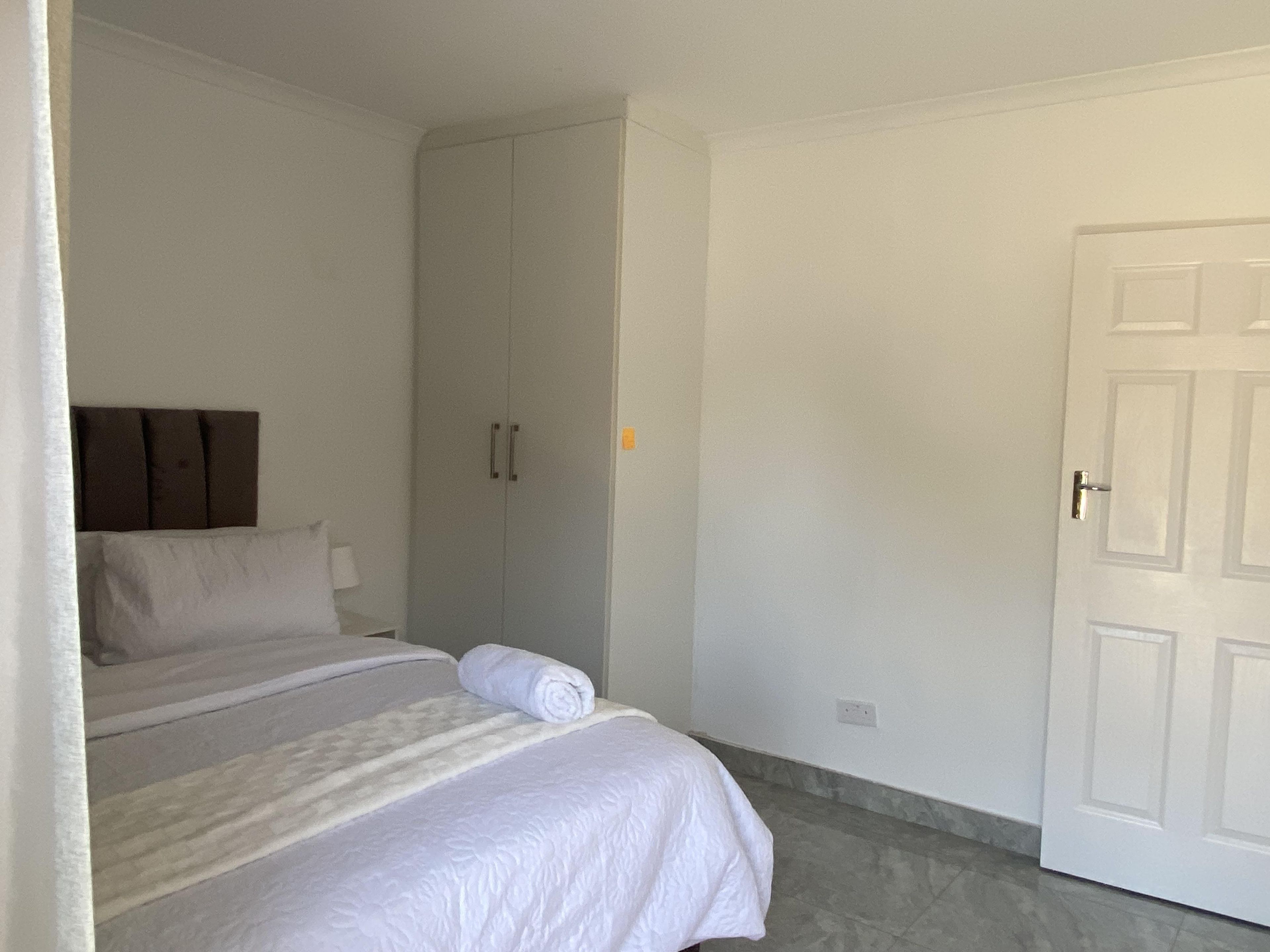 Ein Schlafzimmer mit einem Bett, einem Kleiderschrank und einer Tür.