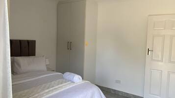 Ein Schlafzimmer mit einem Bett, einem Kleiderschrank und einer Tür.