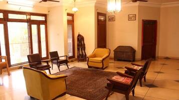 A spacious living room with a large window, a fireplace, and multiple seating options including a sofa and armchairs.