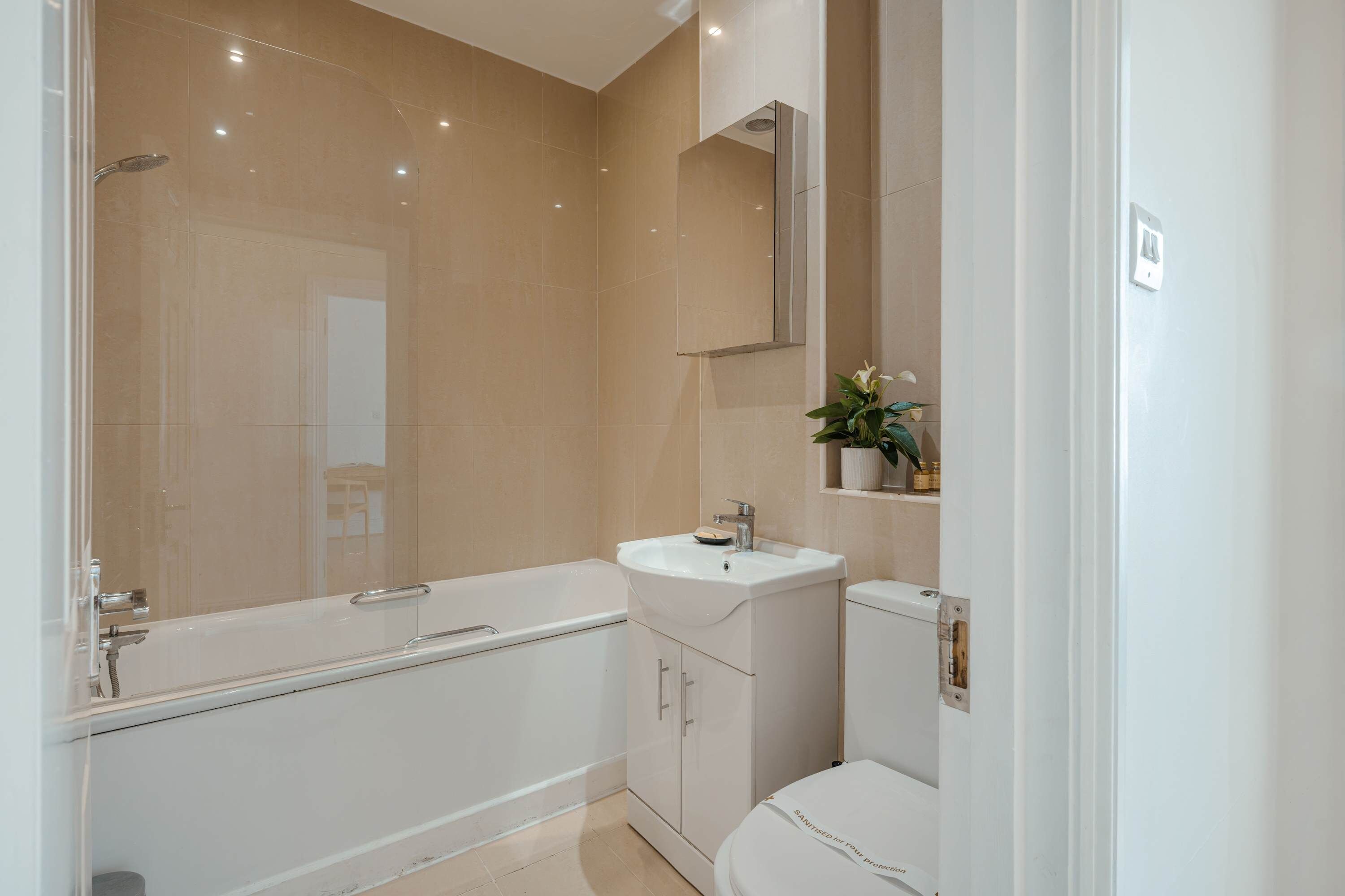 Un bagno moderno con vasca, lavandino e water.