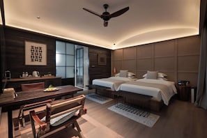 Una habitación de hotel moderna con cama, escritorio, silla y ventilador de techo.
