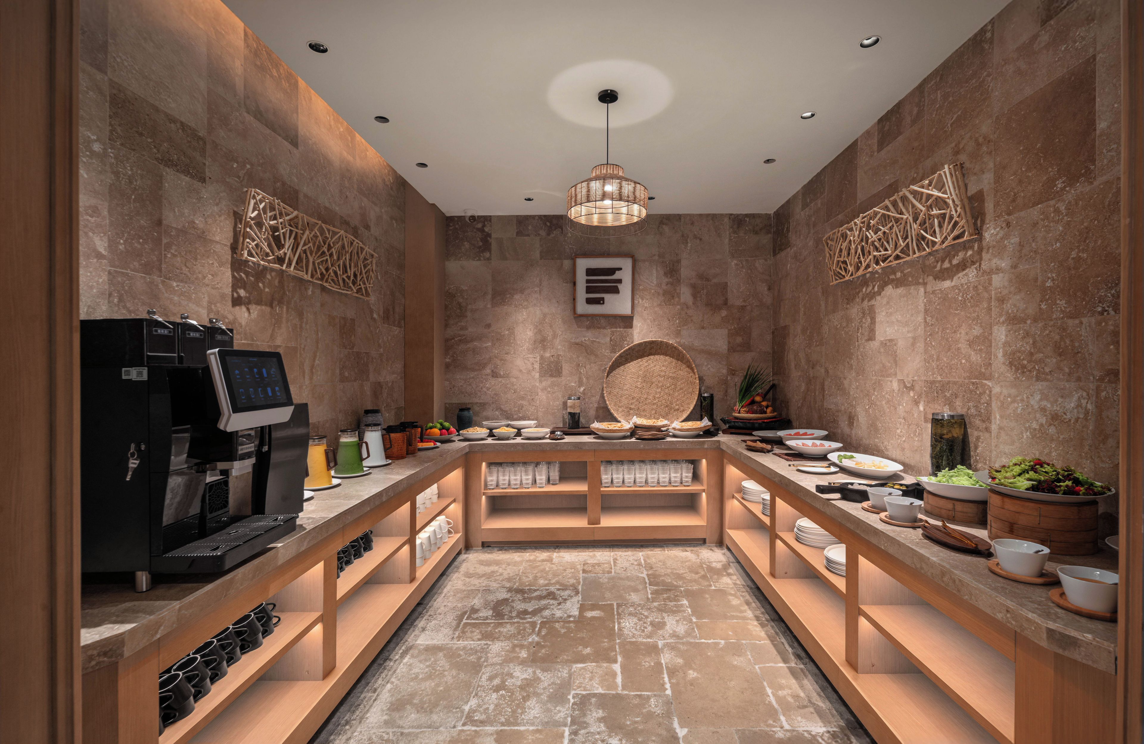 Cocina moderna con cafetera, mesa de buffet y decoración mural.