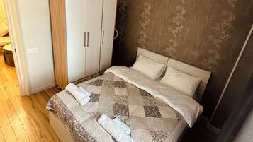 Une chambre à coucher avec un lit, une armoire, un lustre et une tête de lit à motifs.