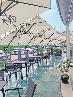 Outdoor seating with umbrellas, a glass-tiled floor, and a view of the street. - The Skytel IMCC Shenzhen (Shenzhen)