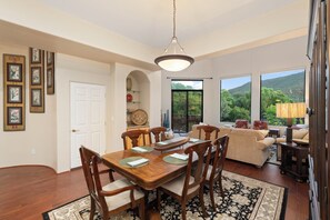 A dining area with a wooden table and chairs, a white door, and framed artwork on the wall. - Les Clés ~ Sedona (Sedona)