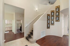 A spacious interior with a wooden staircase, a kitchen area, and a hallway leading to another room. - Les Clés ~ Sedona (Sedona)