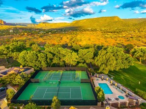 An aerial view of a property with multiple tennis courts, a swimming pool, and surrounding greenery. - Les Clés ~ Sedona (Sedona)