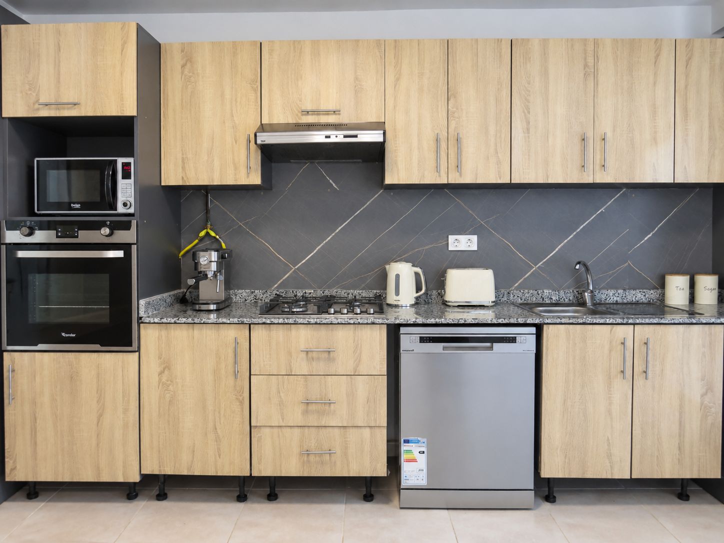 A modern kitchen with wooden cabinets, a built-in microwave, oven, coffee maker, toaster, and dishwasher.