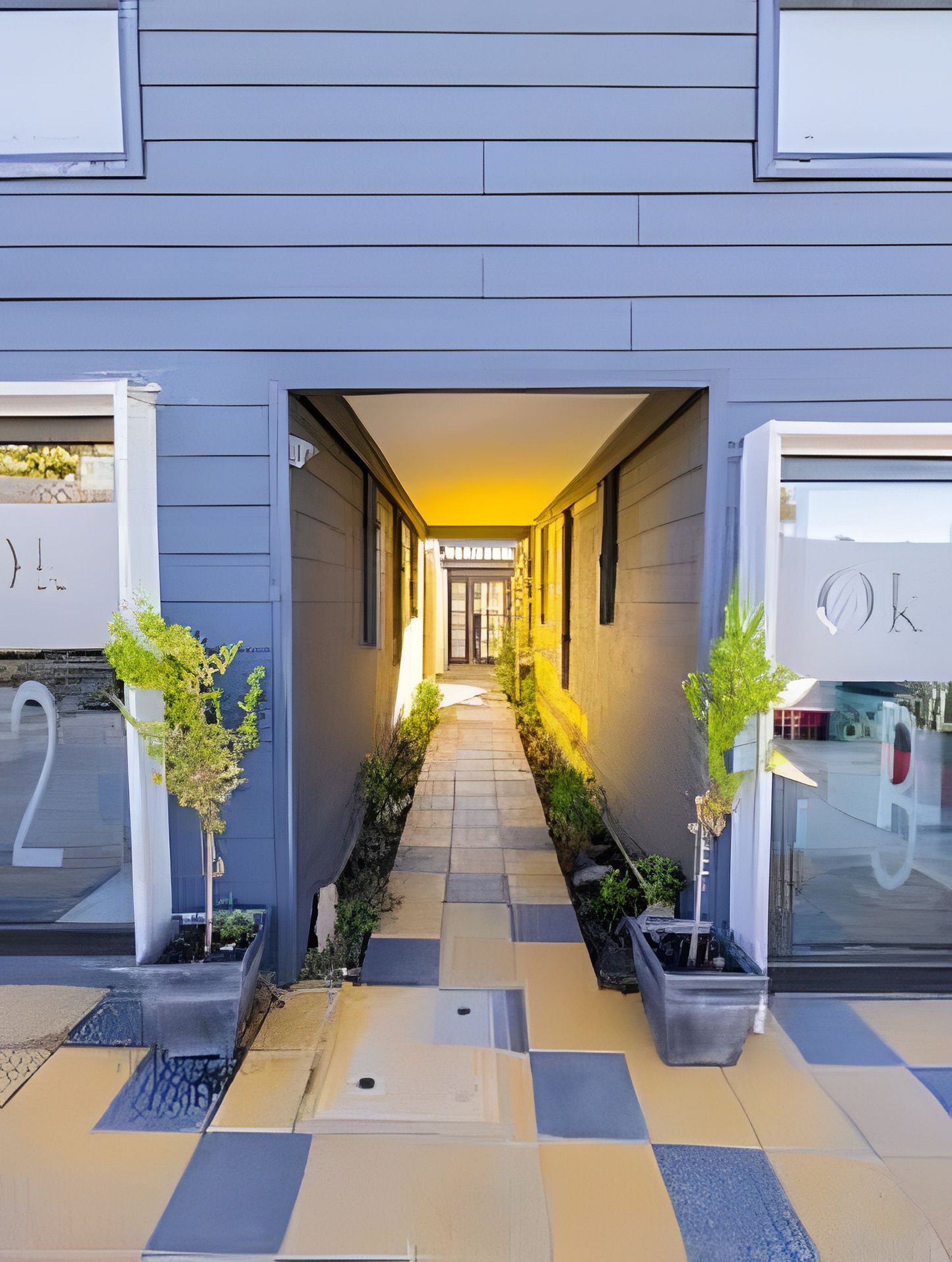 En moderne bygning med en central korridor, der fører til en dør med skiltet 'K'.