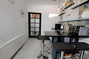 Cozinha moderna com bancada preta, armários brancos e uma grande janela.