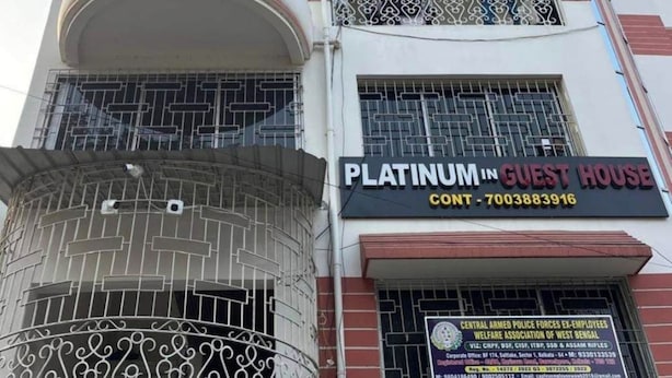 A multi-story building with balconies, a sign for 'Platinum in Guest House,' and a visible building number 'BF174.'