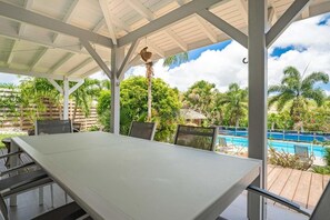 A covered outdoor area with a pool, chairs, and a table. - Just 650 meters from the ocean! 4-bedroom villa with a large pool and bar area (Saint-François)