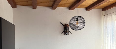 A living room with a sofa, a globe, a wall-mounted light fixture, and a woven basket on the floor.
