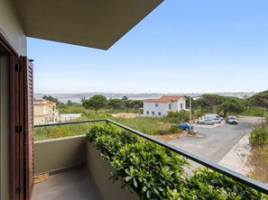 Ein Balkon mit Blick auf ein Wohngebiet, einschließlich Häusern und geparkten Autos.