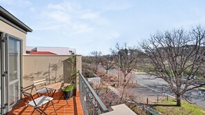 A balcony with a view of a parking lot and trees. - Turner & Tonic at Avron City Escape (Turner)