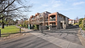 A residential building with a gated entrance, a parking area, and a well-maintained lawn. - Turner & Tonic at Avron City Escape (Turner)