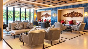 Un moderno vestíbulo de hotel con un conjunto de sofás, sillones y una mesa de centro.