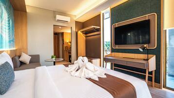 Quarto de hotel com cama grande, escrivaninha, televisão e banheiro.