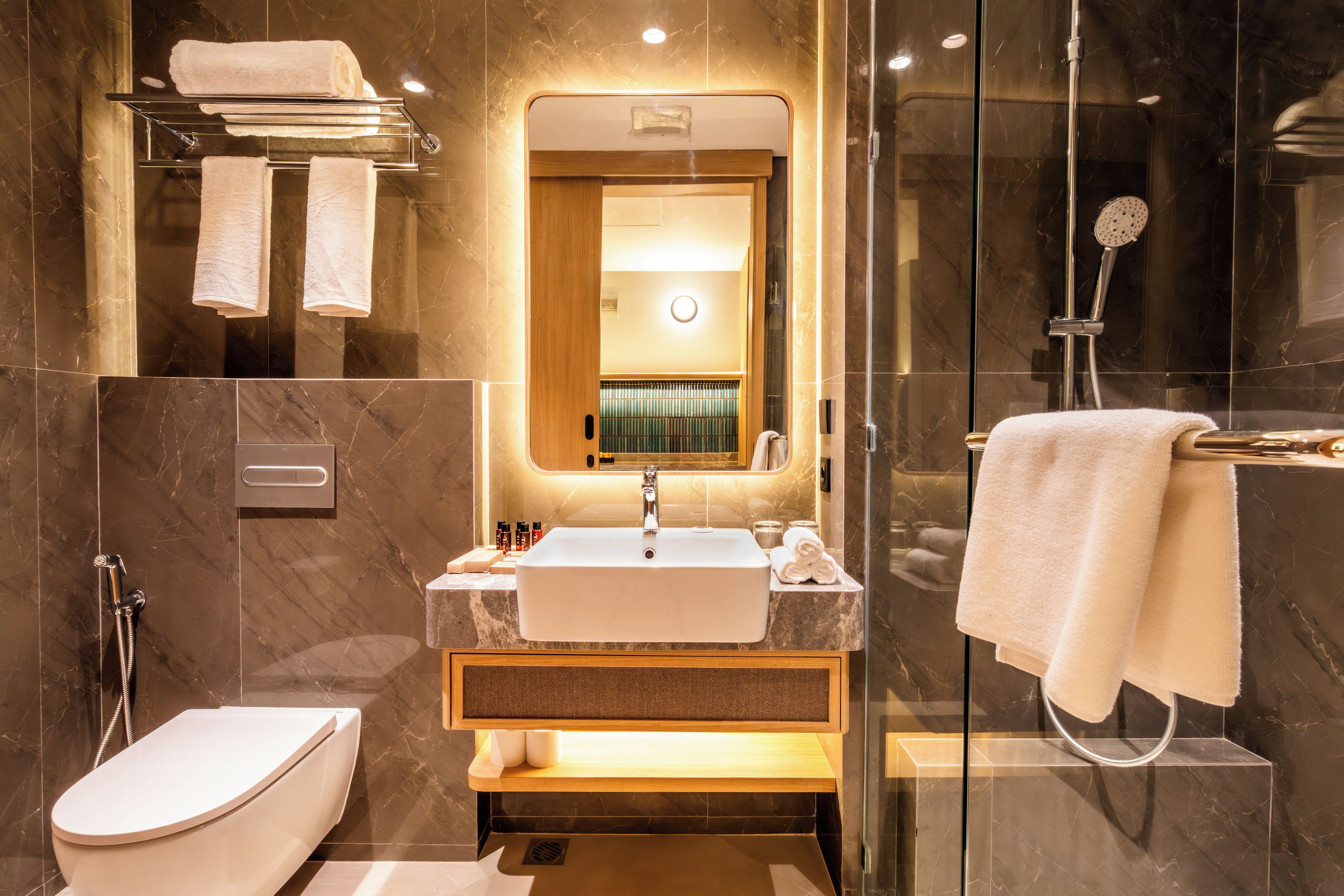 A modern bathroom with a toilet, sink, and shower.