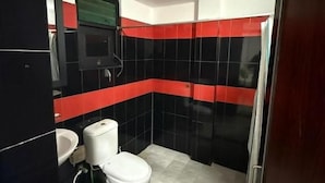 Casa de banho com sanita, lavatório e espelho.